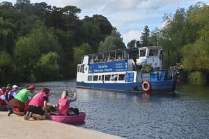 Coracle racers on the banks of the River Severn as the Sabrina boat goes past