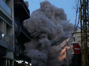 A building collapses as smoke rises following an Israeli strike in central Beirut