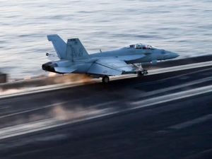 Fighter jet taking off from an aircraft carrier