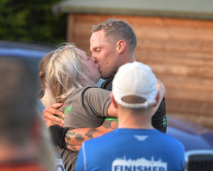 Andy and Sally share an emotional kiss at the end of Andy's 70th triathlon. 