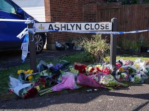 Floral tributes next to a sign for Ashlyn Close, Bushey, Hertfordshire