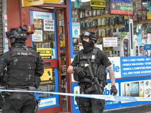 Supporting image for story: Four arrests as armed police seal off road and surround mobile phone shop 