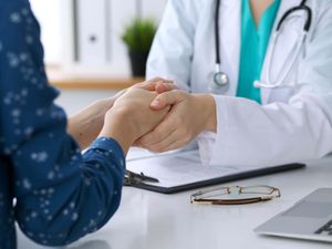 A close up image of a doctor reassuring a patient