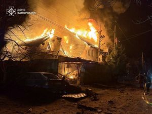 Ukrainian firefighters try to put out a fire after the attack in Zaporizhzhia