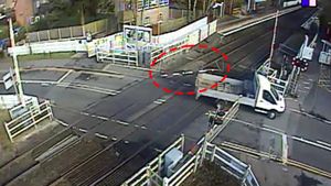 A van damaging a level crossing barrier 