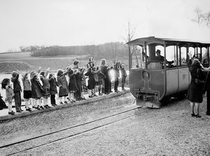 A film crew came to Telford to film for the Nurse of the Year Show. Seven Midlands' nurses competing were filmed in Telford locations, including the tramway at Telford Town Park. Children from the dance and drama club of Holmer Lake First School, Brookside, who were called in by Telford Development Corporation to provide a 'crowd' met television personality Leslie Crowther there. This picture was taken during filming of the tramway. The tram was driven by John Mason