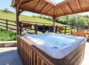 The private hot tub at Parlour Barns, part of the Hollydale Cottages collection in Leek, Staffordshire. Overlooking rolling countryside and a field of friendly Highland cows, the property was awarded Gold for Best Hot Tub Property at the 2025 Sykes Gems Awards.