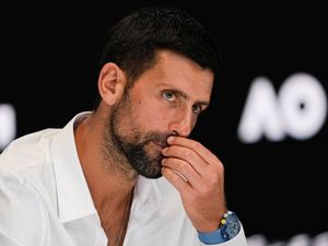 Novak Djokovic listens to a question at a press conference