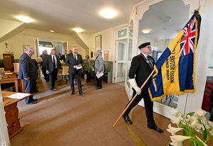 A standard bearer lead the coffin into church