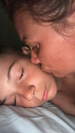 Thea kisses Kion as he lies in a hospital bed. Picture: Thea Williams