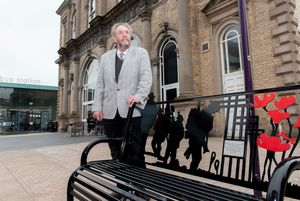 City council leader Councillor Roger Lawrence with the First World War memorial bench which has been placed by Wolverhampton bus station

