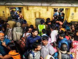 People jostle to board a train at New Delhi station