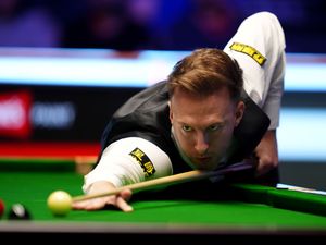 Judd Trump goes to play a shot