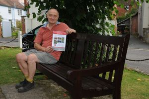 Ludlow War Memorial Fund chairman Graeme Perks with a poster promoting the 'selfie' VJ Day event on the Stan Pugh bench in Ludlow Castle Grounds. 