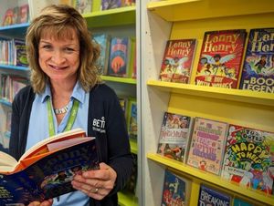 Pictured with The Book of Legends by Sir Lenny Henry is Dudley Library staff member, Sally Cartwright