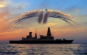 HMS Dragon's Mk8 Lynx Helicopter fired all of its countermeasure flares as the sun sets over the ship