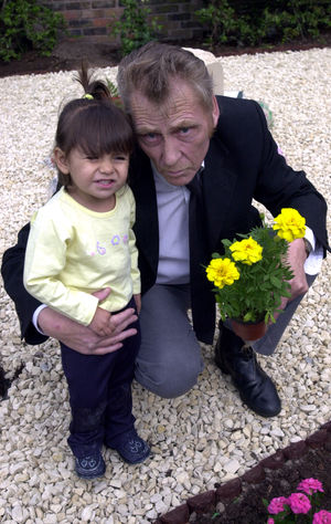 George Lowe with grandchild Tasnim at the family memorial garden in Leegomery