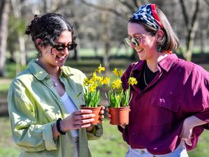 Two women exchange daffodils in Bute Park, Cardiff