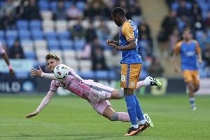 Laurence Maguire is knocked over by Shrewsbury Town striker Bradley Ihionvien