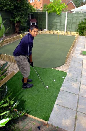 A young Aaron Rai on his putting green in the garden of the family home