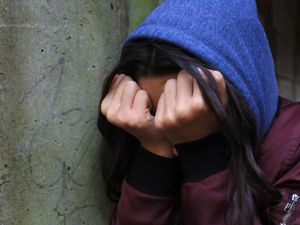 A girl holding her fists to her face