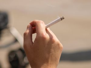 A person smoking outside a pub