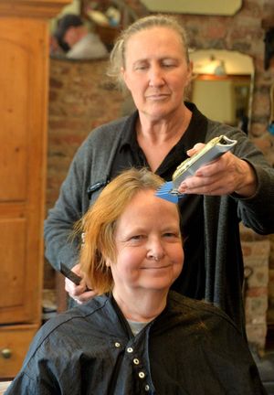 Pat Hirst having her head shaved to raise money for Macmillan Cancer Support. Doing the chopping was Jo Williams.