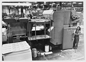 Tony Taylor (top) and John Williams working with the cutting and creasing machine at Baldwins, box and carton makers, 1978