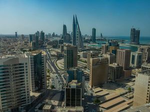A view taken from height of Bahrain, with numerous sky-scrappers in view and the sea off to the right