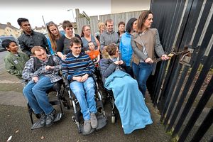Claire at the locked gates to the playground with other supporters