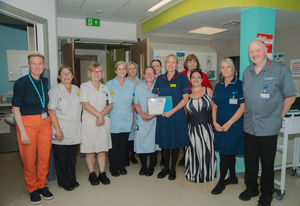 Louise Naylor, Baschurch Day Unit Manager, receiving her RJAH Stars Award from Stacey Keegan, Chief Executive, alongside her team