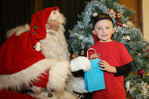 Ray Hulse, 78, from Bridgnorth, Shropshire, who is Britain's longest serving santa who has been doing it for 60 years. Ray Hulse meeting Leo-James, 6, at St Leonard's Hall, Bridgnorth. 03/12/2022.