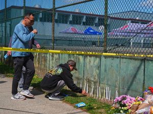 People light candles and gather at a growing memorial next to the scene the day after a driver killed multiple people during a Filipino community festival in Vancouver
