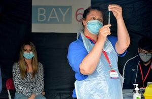 Maddie Richardson looks on as her Pfizer vaccination is prepared