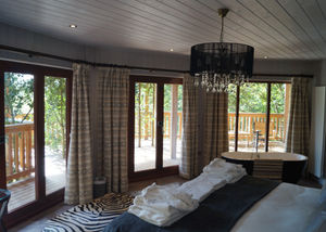 The master bedroom has a huge bed and a free-standing bathtub.