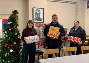 Ollie Locker and Jade Sutton from Wolves Foundation handing out presents to Lucy Cox from the Good Shepherd.