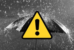 A stock image shows rain falling on a umbrella, with a yellow warning icon added.