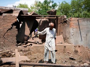 Gulam Hussain inspects his house which was damaged by Pakistani artillery shelling on the outskirts of Jammu, India
