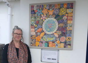 Creative Lead Rosalyn Donati of Pneuma Affinity, pictured with the artwork that resulted from community art project The Mosaic of Harmony, which received an EnviroGrant last year.