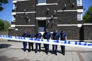 Police officers comb the cordoned area in Camberwell New Road, Southwark, South London