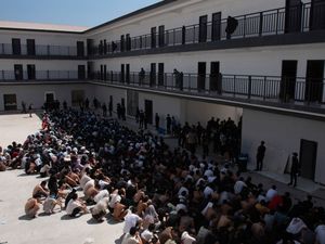 Scores of people in a courtyard