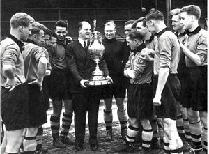 Boss Stan Cullis and his players with the championship trophy which Wolves won for the first time in 1954