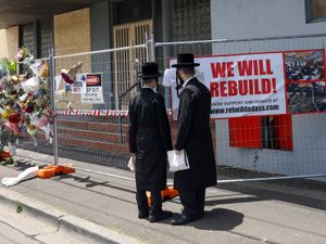 People gather outside the fire damaged Adass Israel Synagogue in Melbourne