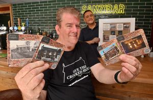 DUDLEY COPYRIGHT NATIONAL WORLD STEVE LEATH 21/08/25 Pictured  in Sedgley at new Micro Bar Sanzibar (formerly the Sands Cafe) is Paul Turner (front) from the Save The Crooked House (Let's Get it Rebuilt) campaign with the four beer mats which have been distributed to pubs around the Black Country. The owner of Sanzibar Dean Sands (back) has a frame with the beer mats in which will hang on the wall permanently in the micro bar.