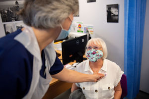 Maureen Hughes, 84, is given a sticker after receiving the injection