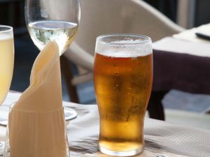 A glass of wine and a pint of beer on a table