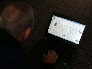 A man looks at Wikipedia on his laptop