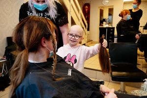 Dulcie showing her mum the first length of hair she chopped off