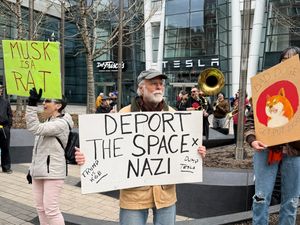 Protesters rally outside a Tesla store in Boston