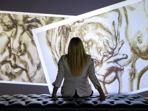 A woman silhouetted against sketches